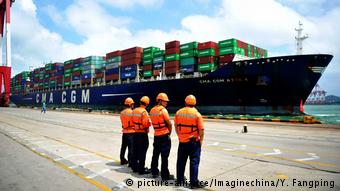 Рабочие перед контейнерным судном в китайском порту 