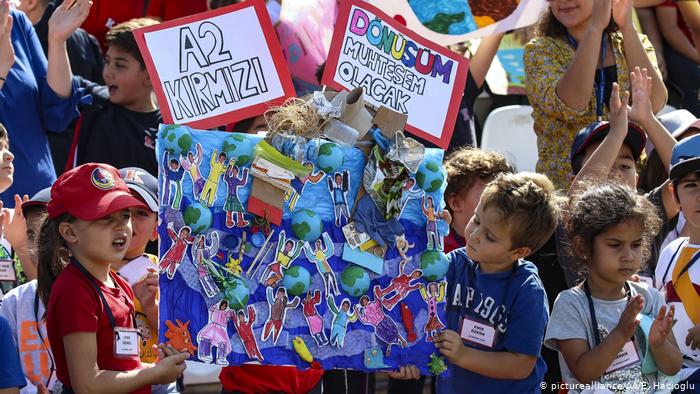 Дети держат в руках разноцветные картинки на акции в защиту климата в Анкаре