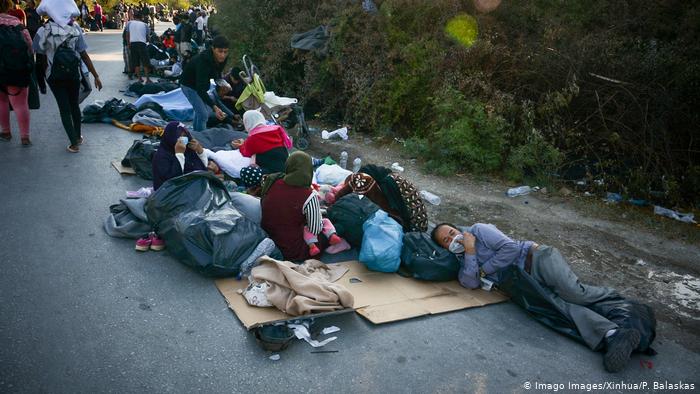 Беженцы из сгоревшего лагеря спят на дороге
