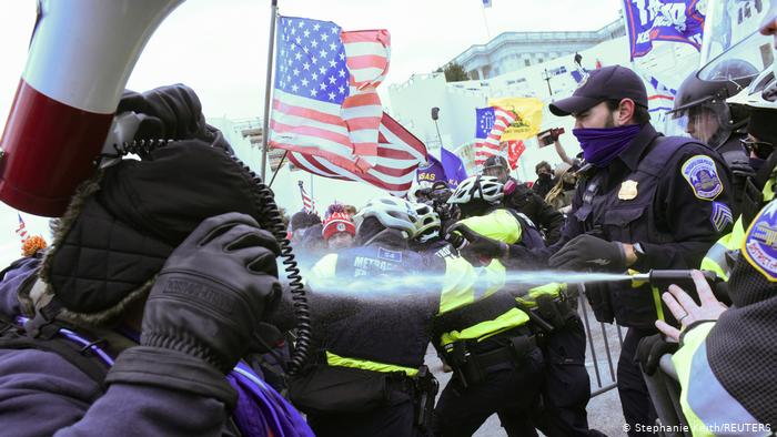 Полицейский у Капитолия в Вашингтоне распыляет слезоточивый газ